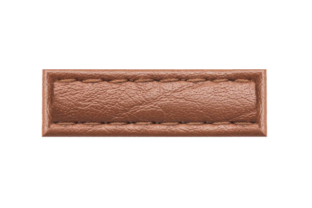 istock Brown leather belt strap closeup isolated on white. Brown stitched leather seam frame label tag isolated on white. Sewing background. 1984989874