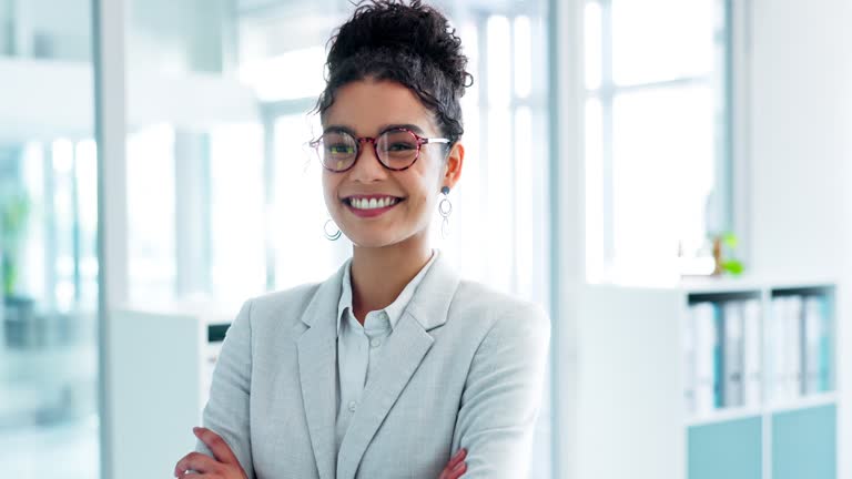 Face, business and woman with a smile, office and arms crossed with a career, consultant and entrepreneur. Portrait, person or employee with glasses, workplace or agent with ambition or administrator