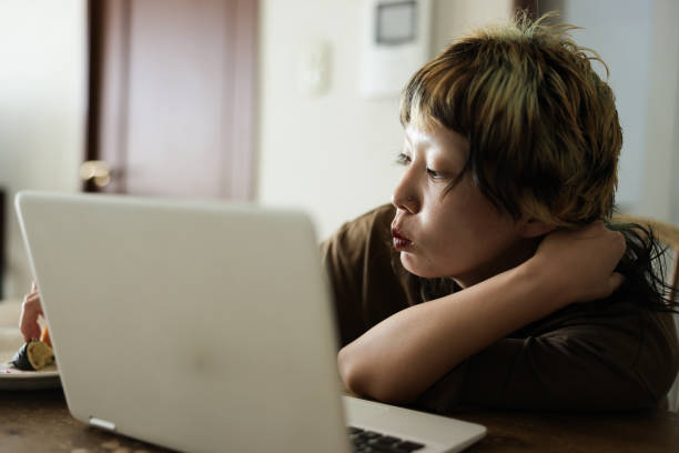 istock Young woman using laptop indoors 1985034042
