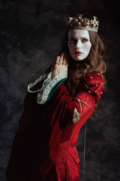 istock medieval queen in red dress with white makeup and crown 1985059507