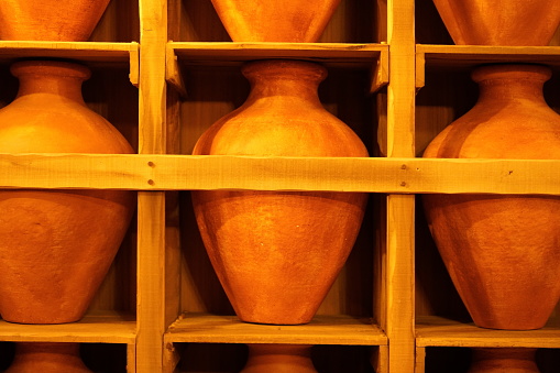 A collection of earth-toned ceramic vases arranged neatly within a rustic containerf