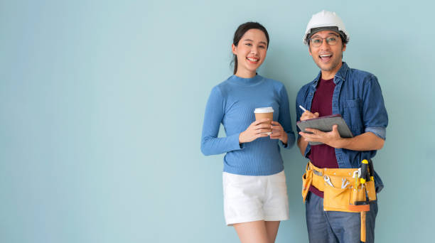 asian young female architect discussing with japanese male building manager contractor for quality control site inspection and at house construction site in room under renovation project. - house quality control examining construction photos et images de collection