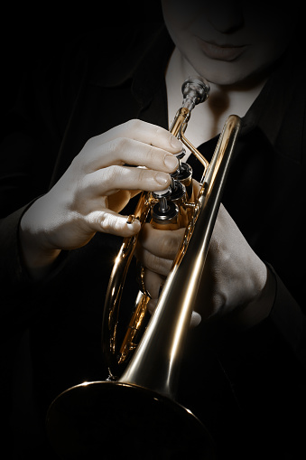 Trumpet player. Trumpeter playing jazz instrument. Orchestra brass musical instruments closeup