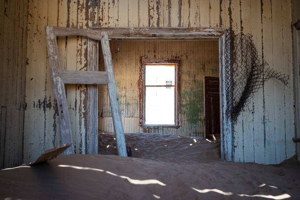 The inside of an abandoned building with damaged walls in an old desert town Room in ruins, with wooden debris and peeling paint desecrate stock pictures, royalty-free photos & images