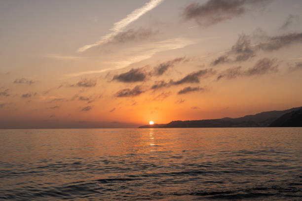 istock Sunset on the beach falling into the water next to the mountain 1985200426