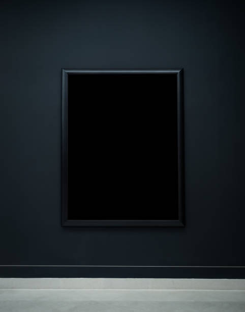 istock Mockup black blank space in thin square picture frame, vertical style, isolated on dark background. Empty single rectangular simple artist frame hanging on dark blue wall background in museum. 1985227962