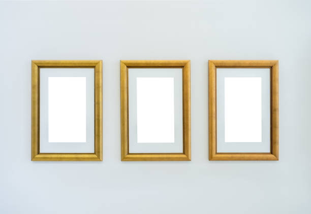 istock Mockup vertical white blank spaces on three luxury golden art frames with mounted hanging on white clean wall background in the museum or art gallery. 1985227967