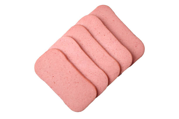 Delicious canned pink ham with salt, spices and herbs on a dark concrete background