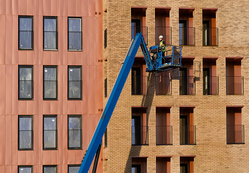 Glasgow, UK, 13th January 2024, Scissor lift being operated by construction workmen for safe access at height