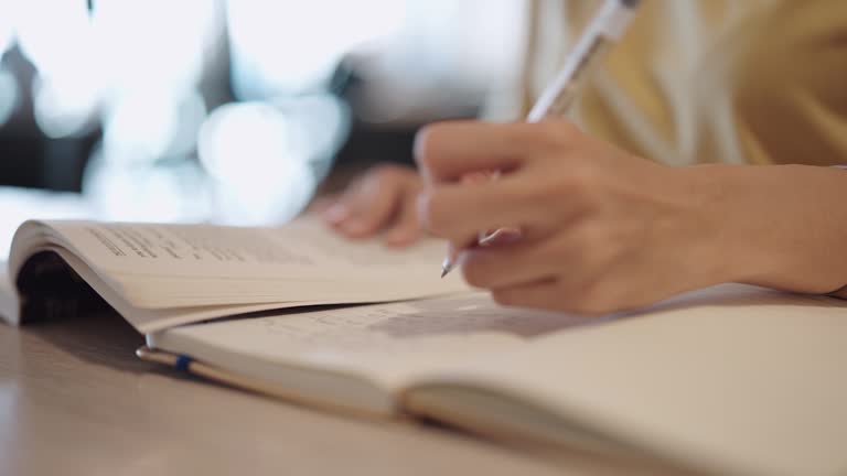 Asian woman taking notes in a notebook before the exam