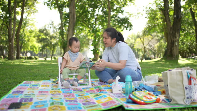 Mother with her Son go to outside the room for picnic in public park and learning in the nature