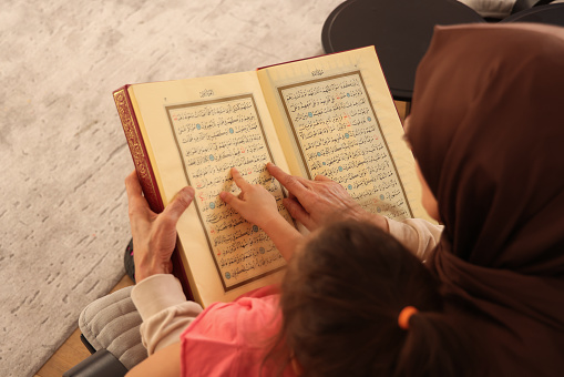 Grandmother teaches her granddaughter to read the Quran