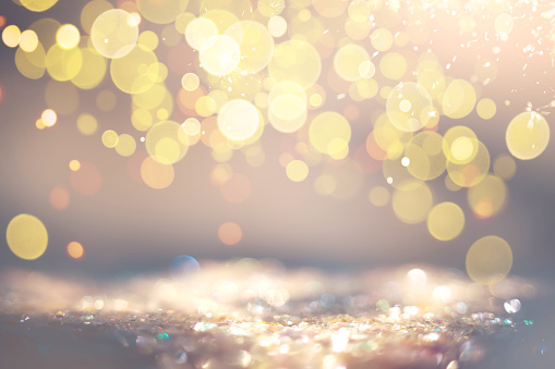 Warm golden bokeh lights create a sparkling, soft-focus backdrop suitable for celebrations and magical moments.