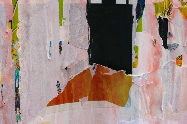 istock Pieces of torn paper peeling off wall used as billboard 1985329411