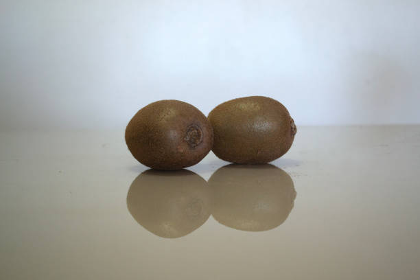 The reflection of some kiwis on a table