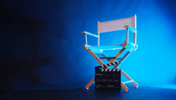 istock Director chair and black clapper board in blue light. 1985383004