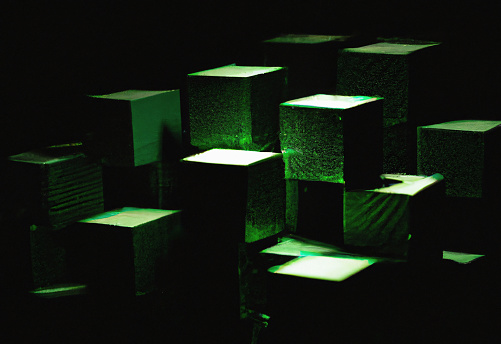 Many cube  blocks in a row with green back lit, quantum parallel computing or blockchain like technology concept