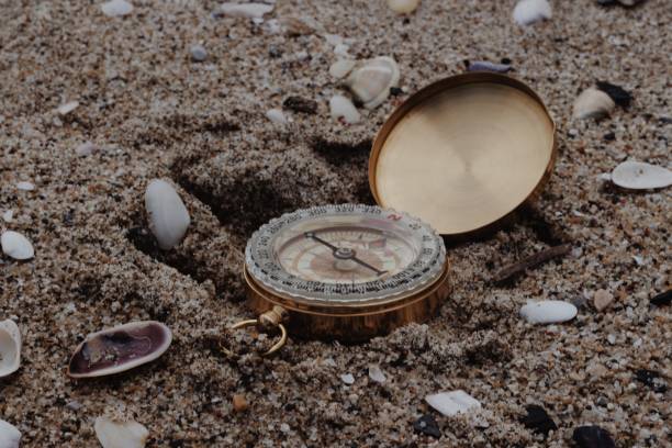 golden compass on the beach in greece - compass exploration the way forward beach fotografías e imágenes de stock