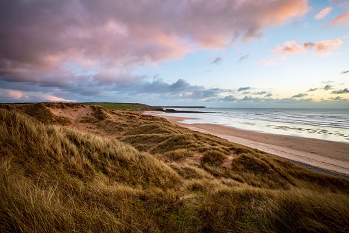 Sand dunes, beach and vibrant sunset at Freshwater West in Pembrokeshire national park, Wales