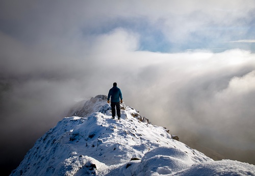 Lone hiker above the clouds in Snowdonia national park, Wales
