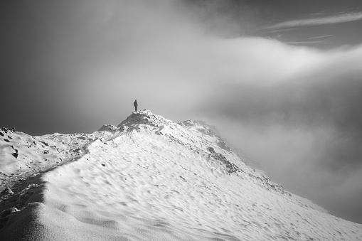 Davos, Switzerland - February 19, 2018: A skier prepares his parachute for speedriding. Speedriding is a new extreme sport and combines skiing with paragliding.. The photo was taken in Switzerland on the Jakobshorn. The Jakobshorn is a very well-known ski area above Davos. Davos itself is known as a winter holiday destination and above all the annual World Economic Forum (WEF) takes place here.