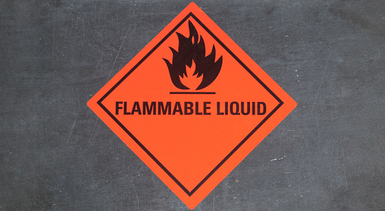 Flammable liquid sticker on gray stone background