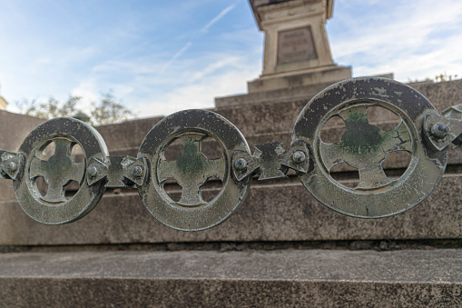 Close up of an ornamental stone chain that delimits a mausoleums entrance | wide angle | cristianity