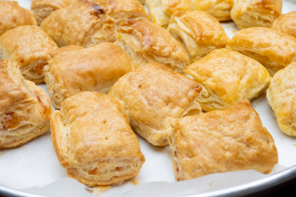 freshly baked puff pastry squares with cheese in tray