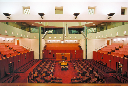 Canberra, ACT, Australia: New Parliament House - Senate chamber of the Australian Senate, a red amphitheater inspired in the colors of the British House of Lords - architect Romaldo Giurgola. Image shot from the public gallery.