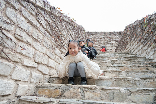 Children sitting on steps looking at camera