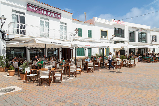 Fornells, Spain, June 22, 2023; People enjoy the terrace in the center of the coastal town of Fornells in Menorca.