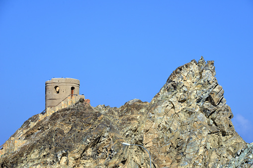 Wilayat Muttrah, Muscat, Oman: Portuguese coastal defence tower at the harbor entrance, perched on a rocky promontory - used as protection against raids from Ottoman forces - visitors can climb the steep stairs and enjoy a panoramic view over the port, Muttrah and Old Muscat - Al-Bahri road, the corniche.