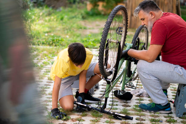 istock Father and son repairing a bicycle in backyard 1985550017