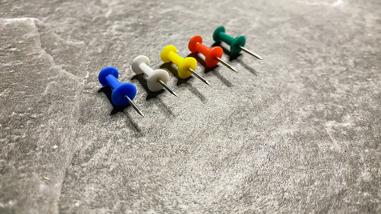 colored pins of different colors on a black background