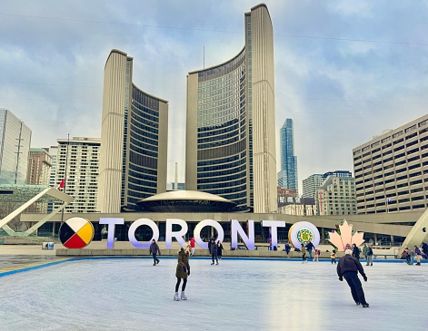 Toronto Jan 2024 Skaters on the outdoor rink by the Toronto Sign and City Hall  at Nathan Phillips Square