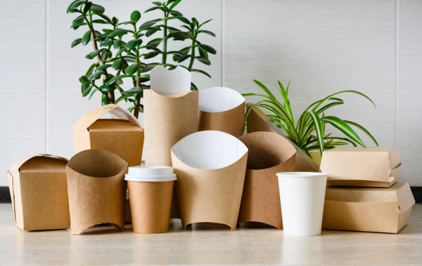 istock An assortment of eco-friendly disposable tableware on a light background with green plants. The concept of paper production to protect nature from plastic waste. 1985564033