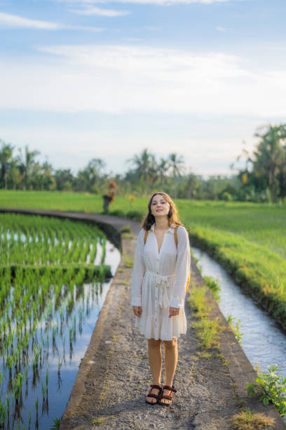 istock Cheerful woman walking on rice paddy on Bali 1985570775