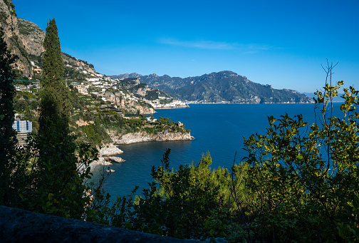 A stunning vista of the picturesque Amalfi coast in southern Italy with picturesque Amalfi town in the background near Naples, featuring a tranquil body of water with a backdrop of majestic mountains and charming buildings nestled along the shore