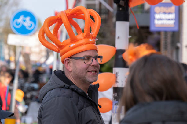 Hulst, Holland - feb 25, 2017: a beautiful costumed girl with a red wig with rainbow colors is dancing in the street parade during carnival in the netherlands in winter