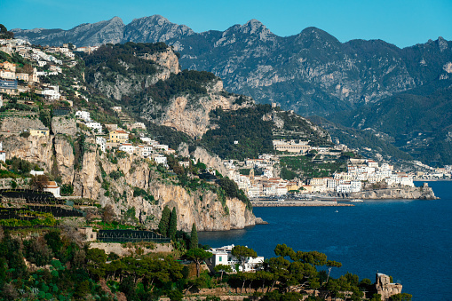 A stunning vista of the picturesque Amalfi coast in southern Italy with picturesque Amalfi town in the background near Naples, featuring a tranquil body of water with a backdrop of majestic mountains and charming buildings nestled along the shore