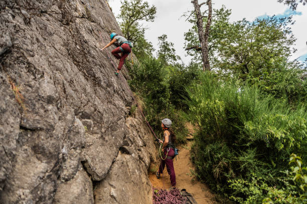 istock Female climbers climbing mountain together 1985617013