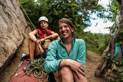 Portrait of a mid adult woman taking a break during climbing with friends outdoors