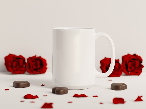 15 oz white coffee cup on a plain white background with red roses, petals and chocolates. Mock up for Valentine’s Day concept. 3D Render.