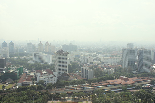 Jakarta City, Indonesia - March 7, 2023 - View from a height of the central area of ​​Jakarta City which is shrouded in smog, it is suspected that air pollution is caused by fumes from motor vehicles, industry and others. In several research publications, the city of Jakarta is one of the cities with the highest levels of air pollution in the world.