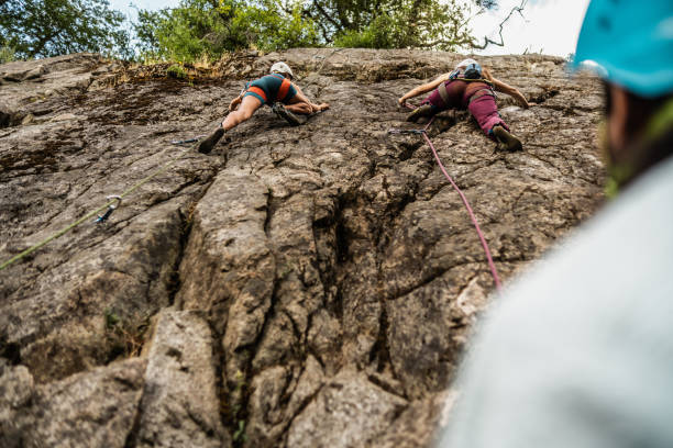 istock Female climbers climbing mountain together 1985635095