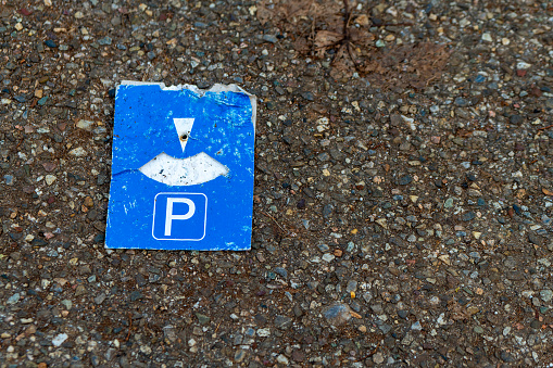 an old parking disc on the asphalt with view from above