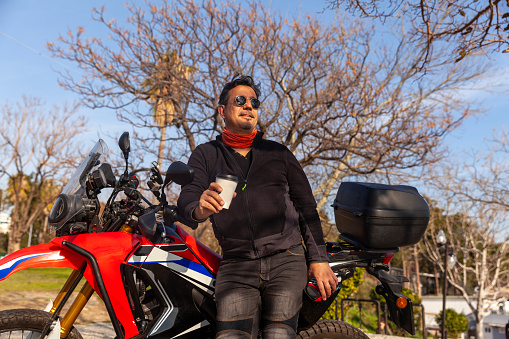 Men with a motorbike holding coffee