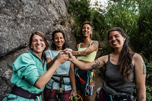 Portrait of climber friends with stacked hands outdoors