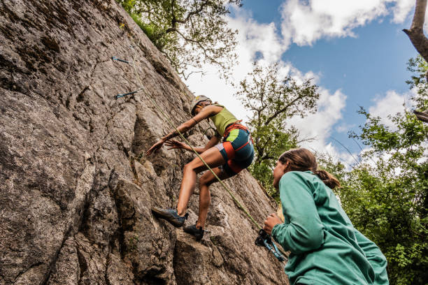 istock Female climbers climbing mountain together 1985657946