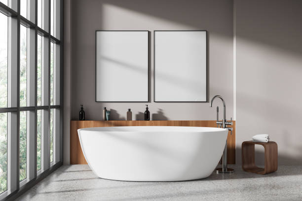 istock Beige bathroom interior with tub and posters 1985680374